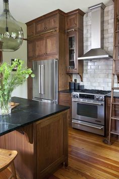 a kitchen with wooden cabinets and stainless steel appliances, along with an island in the middle