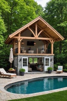 a pool house with an outdoor living area next to it and patio furniture around the pool