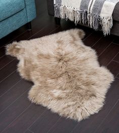 a sheepskin rug is on the floor next to a couch