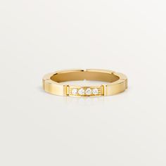 a yellow gold ring with five diamonds on the inside and outside, set against a white background