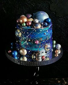 an image of a cake decorated with balls and stars on the top, sitting on a table