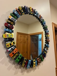 a mirror that has cars on it in the shape of a circle, hanging on a wall