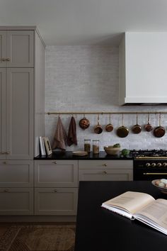 an open book sitting on top of a kitchen counter next to a stove and oven