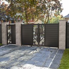 an iron gate is shown in front of a brick wall and grass area with trees