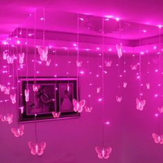 pink lights hanging from the ceiling in a room with butterflies on it and a mirror