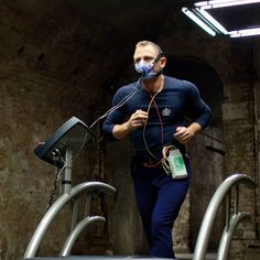 a man wearing a face mask while running on a treadmill with an oxygen tube in his mouth