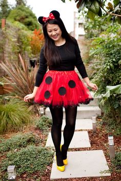 a woman wearing a red and black dress with a minnie mouse ears on her head