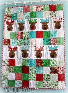 a quilted christmas wall hanging with reindeers on it