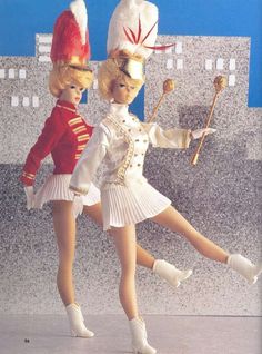 two dolls are dressed in white and red outfits