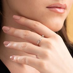 a close up of a person wearing a ring with a diamond on it's finger