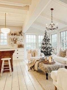 a living room filled with furniture and a christmas tree in the middle of the room