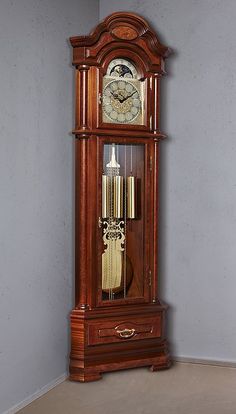 an old grandfather clock with pendulums on the front and sides, in a corner