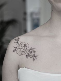 a woman with a flower tattoo on her shoulder