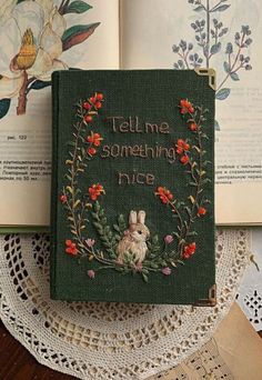 an old book with some flowers on it and the words tell me something nice written inside