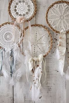 three white doily dream catchers hanging on a wall