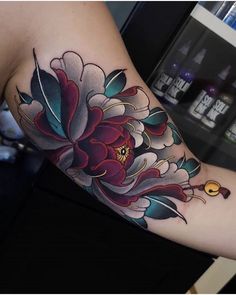 a woman's arm with a flower tattoo on the left side of her arm