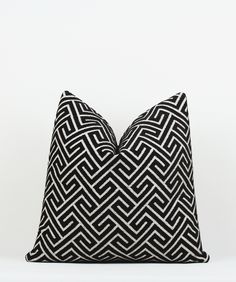 a black and white pillow sitting on top of a table