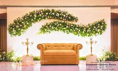 a couch sitting in the middle of a room with flowers on it's wall