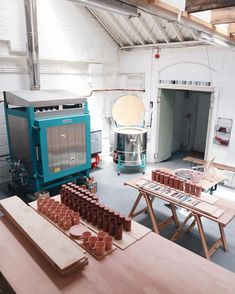 a room filled with lots of different types of pottery on top of wooden tables and chairs