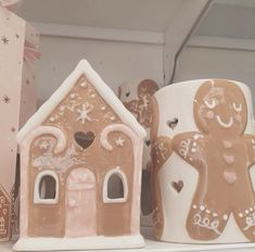 two ceramic gingerbread houses on a shelf