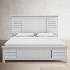 a white bed sitting on top of a wooden floor