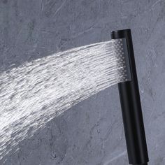 a shower head with water coming out of it's spout on a marble surface