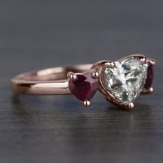 two heart shaped engagement rings with pink and white stones on them, one in rose gold