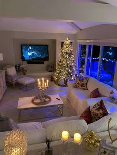 a living room filled with furniture and a christmas tree in front of a large window