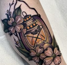 a tattoo with flowers and a lantern on it