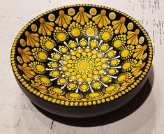 a yellow and black bowl sitting on top of a white table