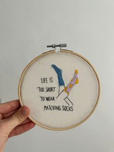 someone is holding up a cross stitch hoop with the words life is too short to wear matching socks