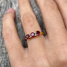 Three gorgeous little faceted garnet gemstones flanked with two tiny diamonds besides the middle one and set in gold vermeil. The open band is adjustable allowing it to be sized up a size. Garnet Rings With Rose Cut Diamonds For Promise, Garnet Promise Ring With Rose Cut Diamonds, Ruby Ring With Rose Cut Diamonds, Gold Rings With Rose Cut Diamonds And Garnet, Gold Garnet Ring With Rose Cut Diamonds, Dainty Ruby Ring With Rose Cut Diamonds, Red Gemstone Diamond Ring Dainty Style, Gold Garnet Open Ring, Red Diamond Dainty Ring