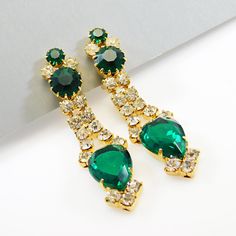 Long vintage green rhinestone earrings are stunning. Rich green rhinestones and clear rhinestones are set in beautiful gold tone metal - all prong set. Clip on backs and unsigned, these measure 2 3/4 inch long. These are not the cheap, lightweight modern type stones. NIce weight glass and in like new condition. Any dark on the stone is just glare - they are all clear and brilliant. Listing a fabulous matching bib, fringe necklace soon. Find lots more vintage jewelry at Purple Daisy Jewelry! http Romantic Earrings, Daisy Jewelry, Blue Crystal Earrings, Gold Bar Earrings, Black Stud Earrings, Purple Daisy, Unusual Earrings, Bar Stud Earrings, Fringe Necklace