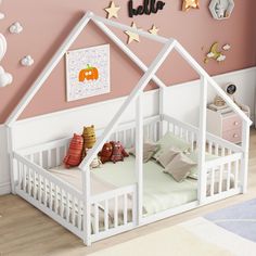 a child's bedroom with a white doll house bed and pink walls, decorated with gold stars