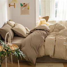 a bed with brown and white checkered comforter in a bedroom next to a window