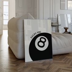 a white couch sitting on top of a hard wood floor next to a sign that says lucky you