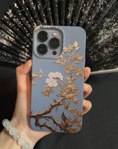 a person holding an iphone case with flowers on it