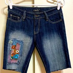 New W/O Original Tags * Clash Jeans Detailed Embroideries Front & Back 5 Pkt Style Denim 10" Long Shorts * Size 7 (28w) 79% Cotton 20% Polyester 1% Spandex For An Easy To Wear & Easy To Care For Shorts Dark Wash W Faded Areas Beautiful Detailed Embroidery Front & Back Waist Is 14" (28w) 8" Rise 10" Inseam Brand New Condition Never Been Worn Casual Denim Bottoms With Embroidered Patch, Casual Multicolor Floral Embroidered Bottoms, Casual Multicolor Floral Embroidery Bottoms, Blue Embroidered Denim Shorts, Cotton Bottoms With Multicolor Embroidery, Blue Embroidered Short Length Jeans, Embroidered Mid-rise Cotton Shorts, Embroidered Cotton Jean Shorts, Embroidered Cotton Short Jeans