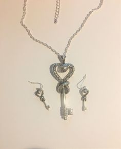 "Rhodium Plated Snake Heart Key Pendant with Swarovski Crystals and Earrings Jewelry Set, Statement Set Rhodium Plated Necklace is 18\" Long with an extension i AM SELLING 1- NECKLACE ONLY ! Pendant is 3 1/4\" Long including the Bale... Swarovski Crystals are at the bottom of the Key. Snake Heart and Key Earrings are Earrings are 1 1/2 \" Long with the Hook. STATEMENT SET Ask questions as I do not accept returns Thank You !" Silver Heart Jewelry Sets For Anniversary, Silver Heart Jewelry Sets For Party, Valentine's Day Sterling Silver Jewelry Sets, Metal Jewelry With Matching Heart Pendant Earrings, Heart Pendant Jewelry With Matching Earrings, Silver Pendant Earrings For Valentine's Day, Silver Heart-shaped Jewelry Sets For Anniversary, Silver Jewelry Sets With Matching Earrings For Valentine's Day, Metal Heart Pendant Jewelry With Matching Earrings