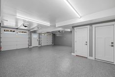 an empty garage with three doors and two fire hydrants on the side of the room