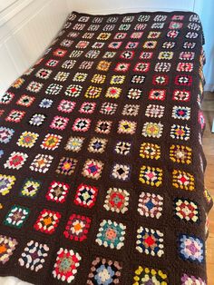 a crocheted blanket is laying on the bed