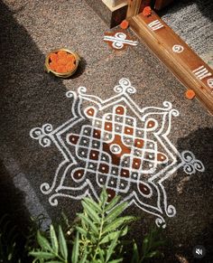 an artistic design is on the ground next to a bowl of oranges and spices