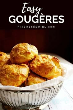 a bowl filled with baked goods sitting on top of a wooden table and text overlay reads easy gougeres