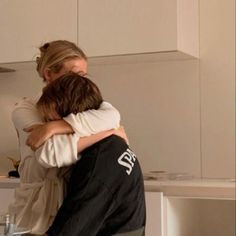 two people hugging each other in the kitchen