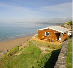 a house sitting on top of a hill next to the ocean