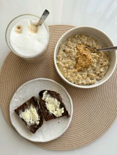 two bowls of oatmeal and a bowl of milk on a placemat