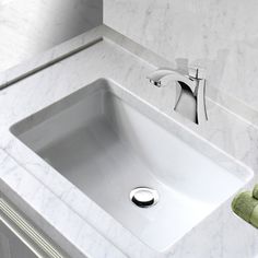 a white bathroom sink sitting under a faucet