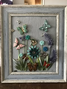 a frame with flowers and butterflies in it