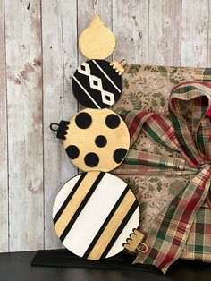 a christmas decoration made out of wood and paper on a shelf next to a wrapped present