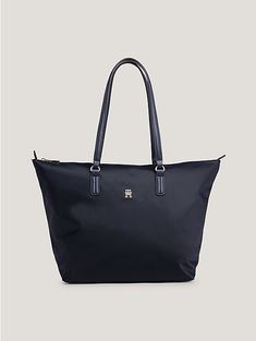 Embrace the spirit of Tommy Hilfiger with this handy tote, decorated with vibrant signature tape seams and contrast straps.  Highlights  • Recycled nylon blend • Smooth finish • Zip closure • Two top handles • One main compartment • One interior zipped pocket ��• Signature tape trim on seams • TH monogram plaque on front • Tommy Hilfiger branding  Shape & fit  • 48 x 14 x 32cm • Capacity 10.3L  Composition & care  • 90% recycled nylon… Tommy Hilfiger Aesthetic, Tommy Hilfiger Bag, Tommy Hilfiger Bags, Zip Tote, Tommy Hilfiger Women, Beach Tote, Womens Tote, Womens Tote Bags